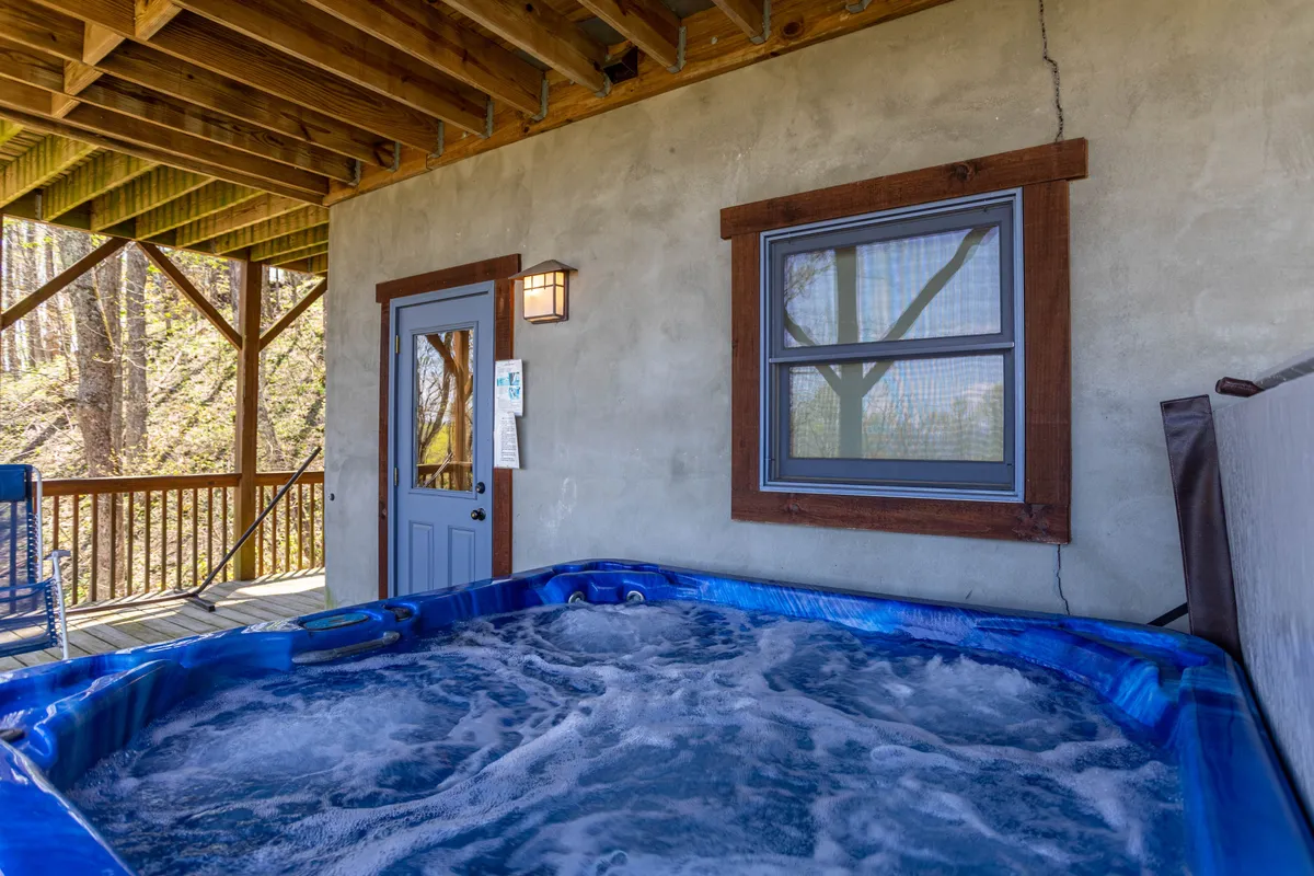 This image highlights a tranquil hot tub area inside the cabin, with a door and window revealing views of the outdoors. The atmosphere is calm and inviting, ideal for unwinding after a day out exploring the local area.